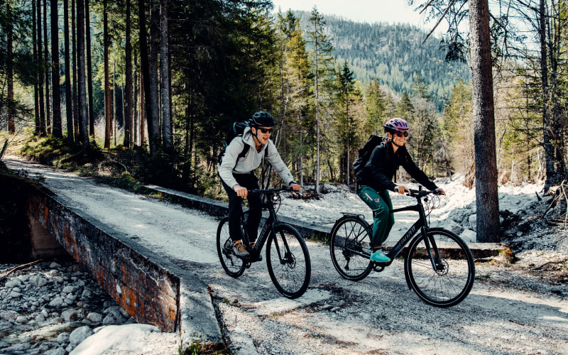 Ein Paar fährt mit dem Specialized e-Bike durch den Wald