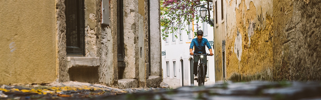 Ein Mann zwischen GebÃ¤uden auf seinem Specialized e-Bike