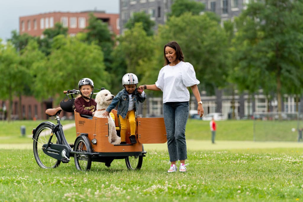 Frau mit Kindern und Hund auf einem Lastenrad von Babboe