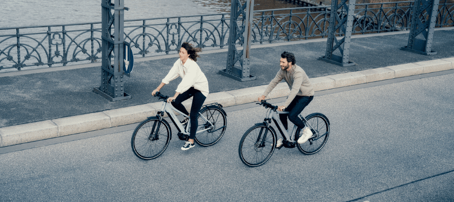 Zwei Fahrer auf ihren Riese & Müller e-Bikes fahren über eine Brücke