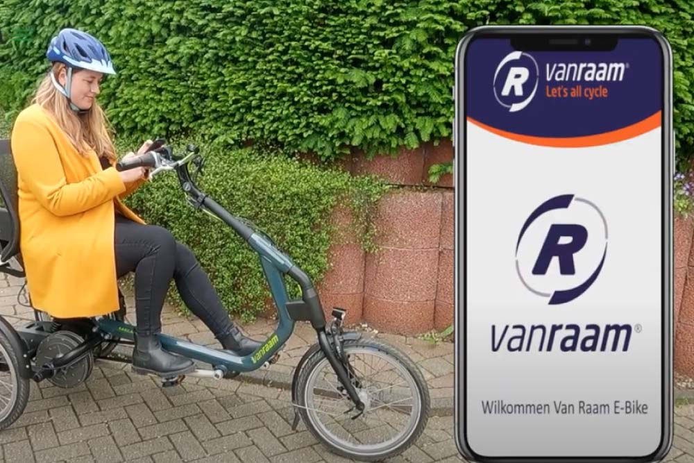 Eine Frau sitzt auf dem Van Raam Easy Rider während die die Van Raam App nutzt