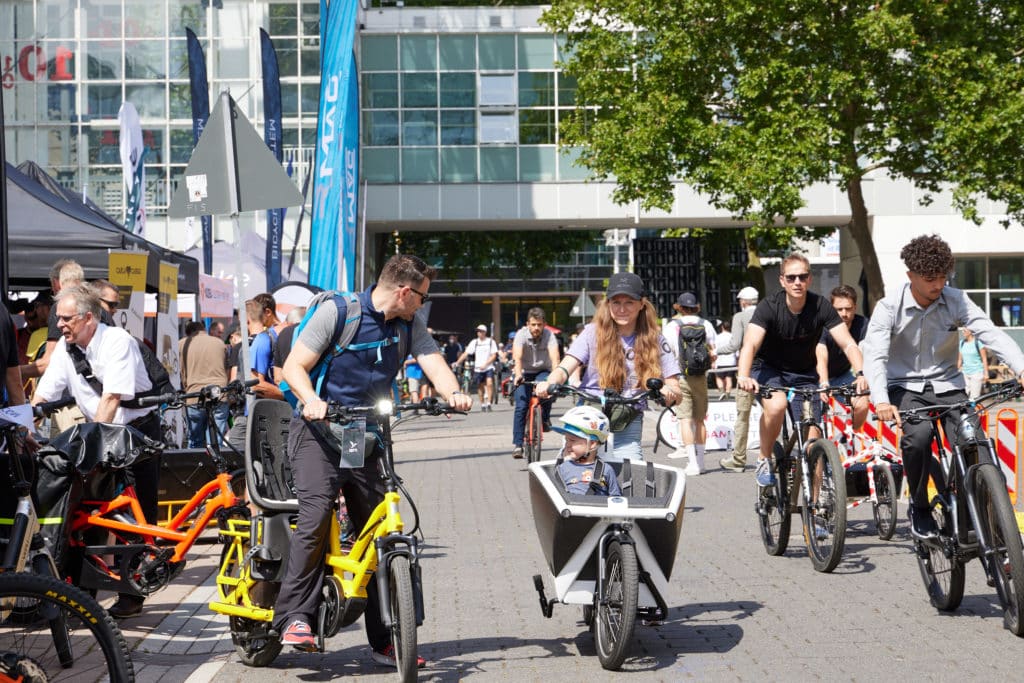 Mehrere Menschen fahren auf einer asphaltierten Strecke mit verschiedenen e-Bike Modellen