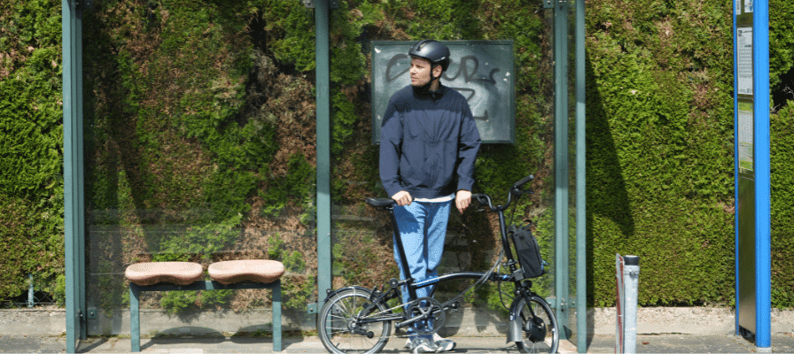 Lennart wartet mit Brompton an Bushaltestelle