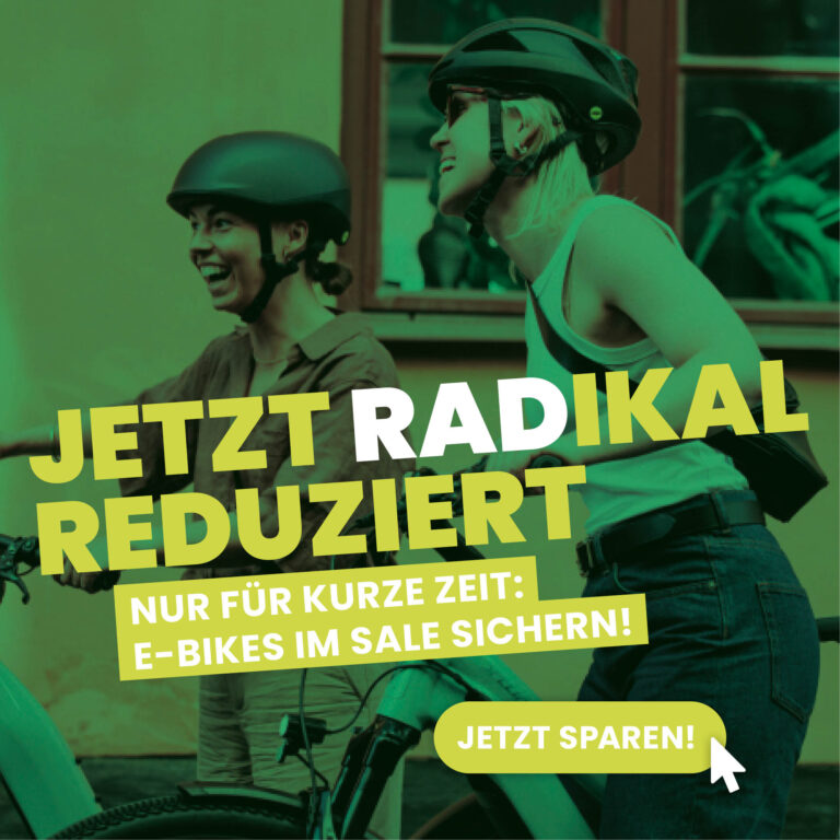 Zwei Frauen mit Fahrradhelmen lachen gemeinsam mit ihren E-Bikes im Sommer – Textaufschrift ‚Jetzt RADikal reduziert – nur für kurze Zeit: E-Bikes im Sale sichern!‘